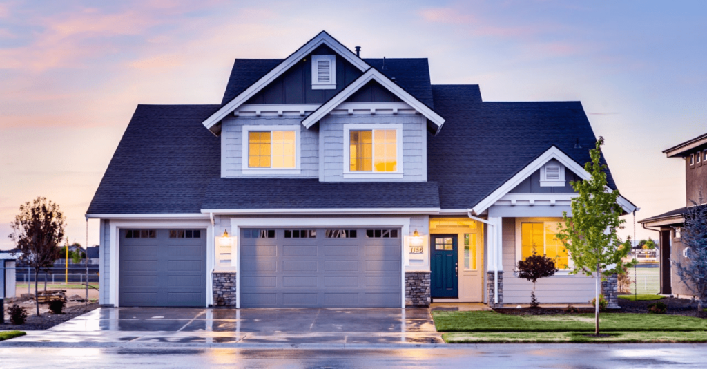 A house with two garage doors and a blue sky