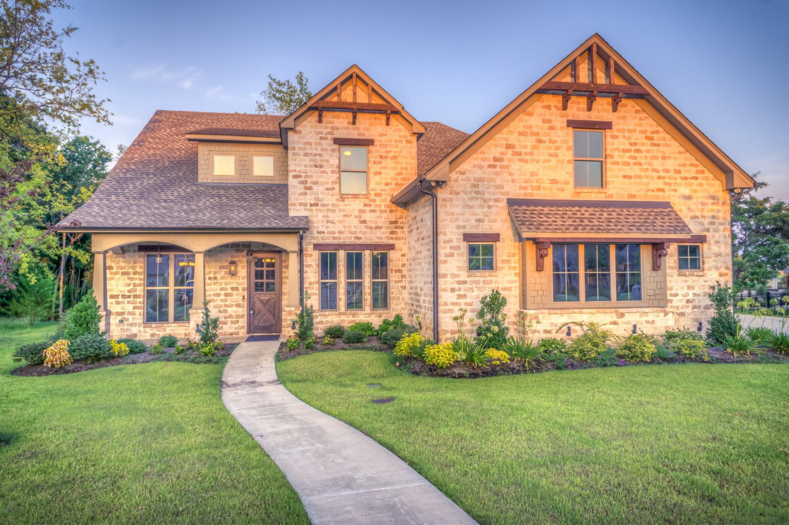 A brick house with a stone walkway in front of it.